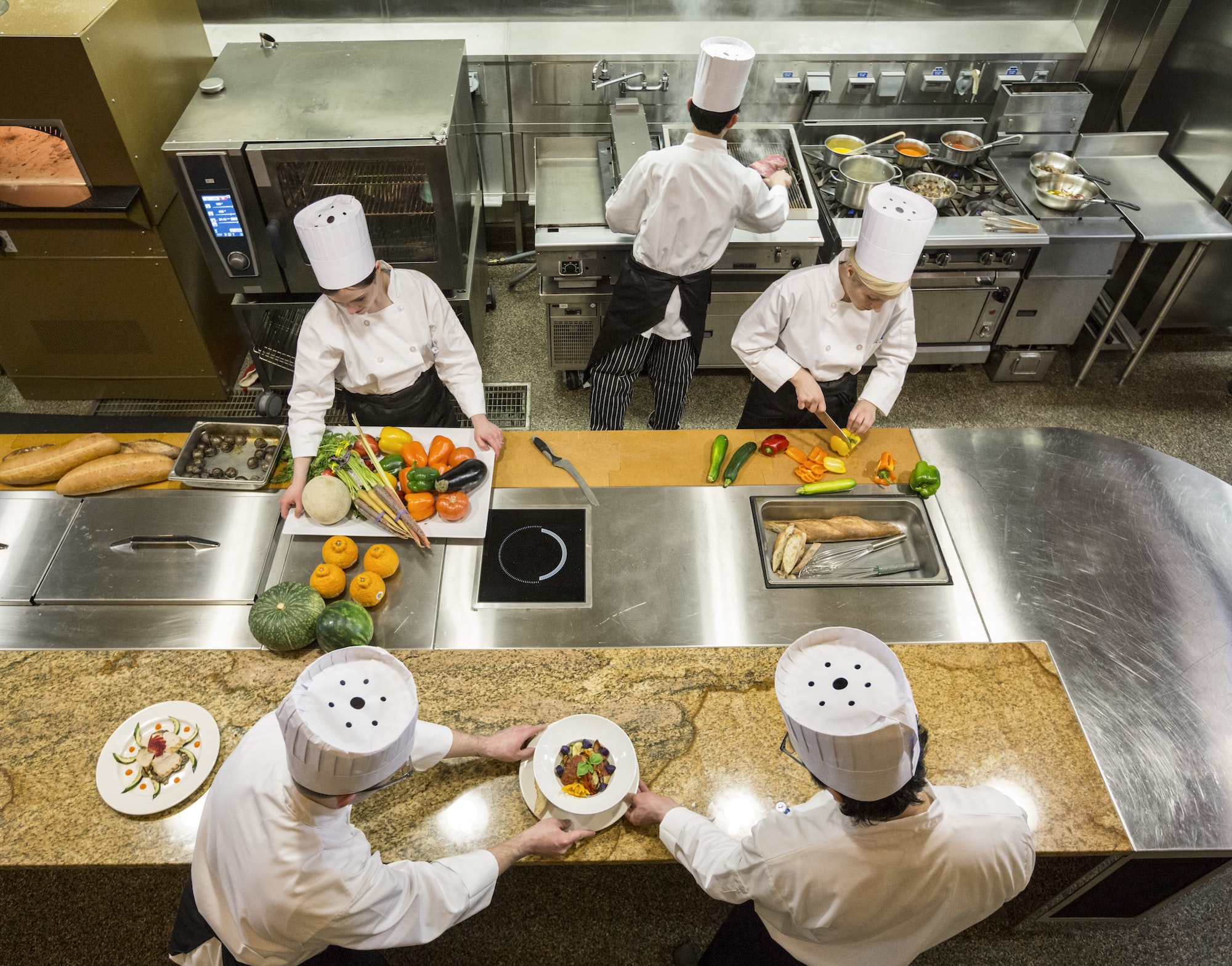 a-view-looking-down-on-a-crew-of-chefs-working-in-a-commercial-kitchen-.jpg